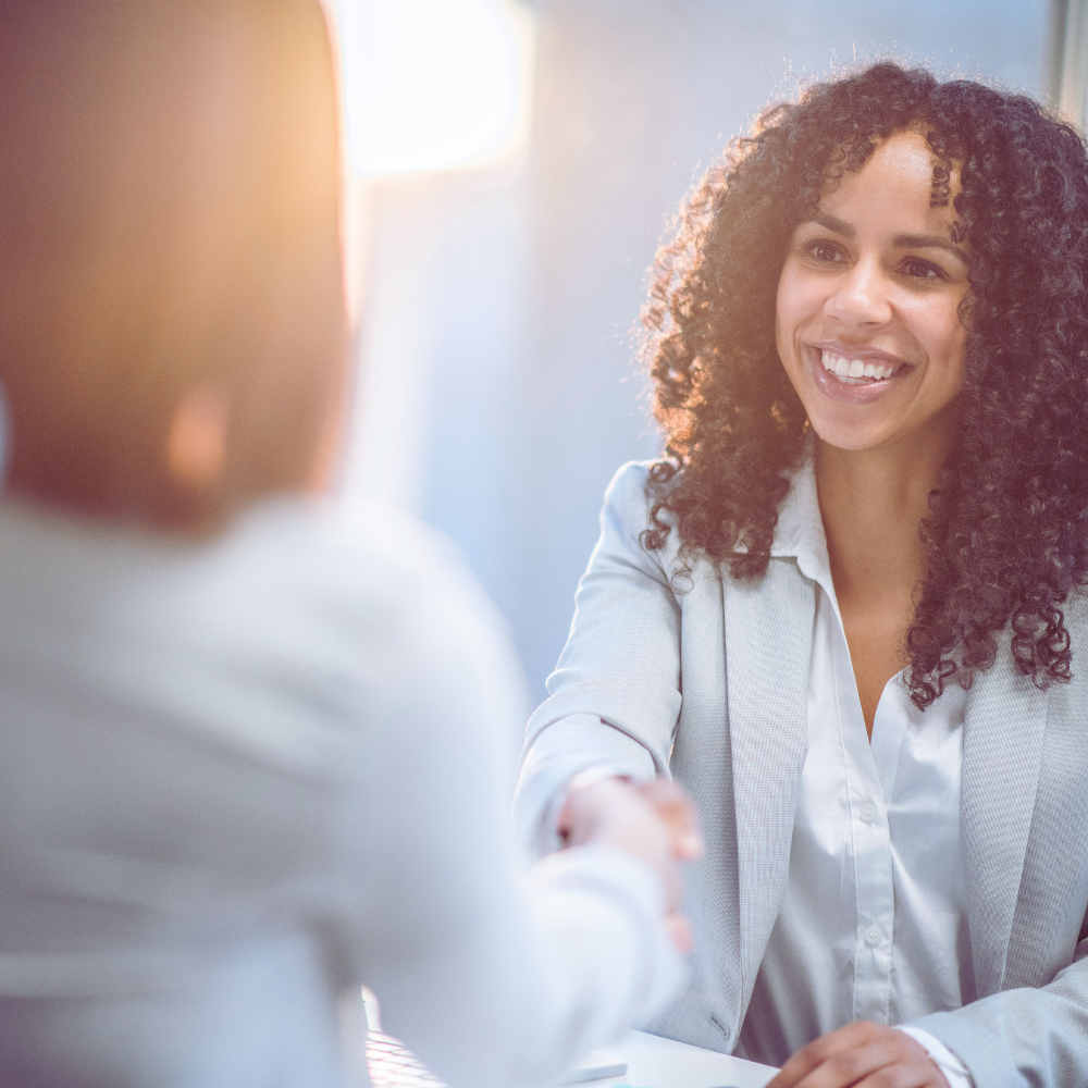 Smiling woman shaking hands in professional business setting