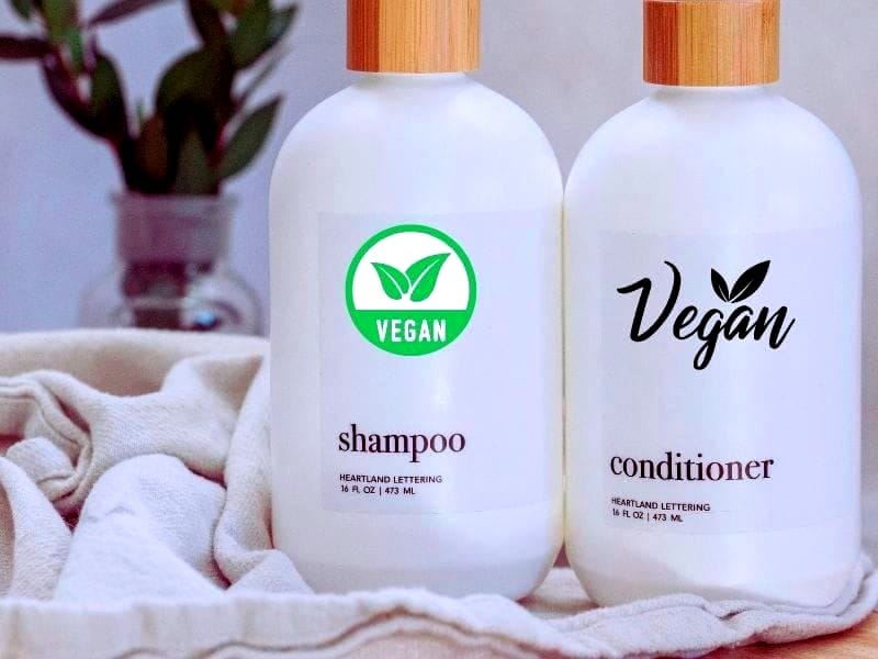 Vegan shampoo and conditioner bottles on a soft towel, promoting green beauty and sustainable haircare choices.