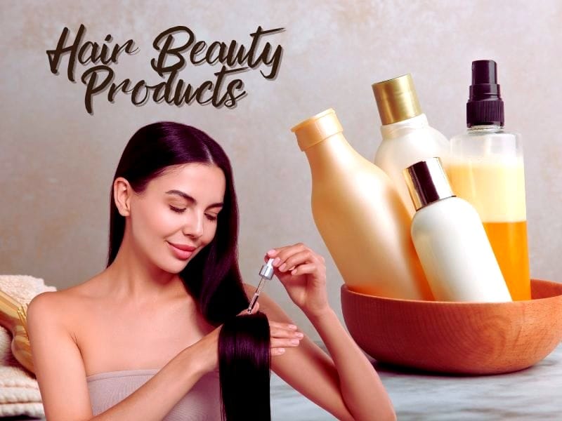 A woman applying oil to her sleek, dark hair with a variety of hair beauty products in eco-friendly bottles nearby.