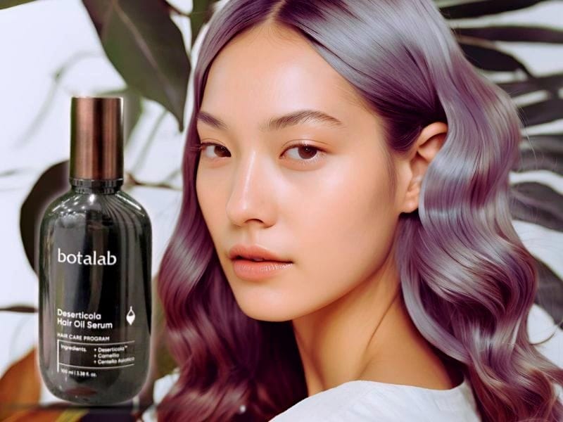 A woman with smooth, shiny purple-tinted hair next to a Botalab Deserticola Hair Oil Serum, promoting non-toxic beauty for healthy, radiant hair.