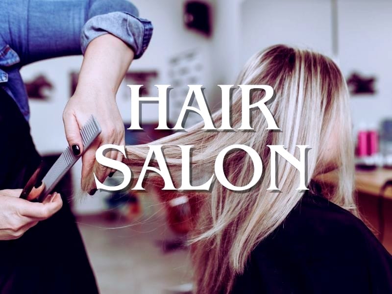 A stylist combing a client's blonde hair at a professional salon, emphasizing the benefits of natural hair care products.