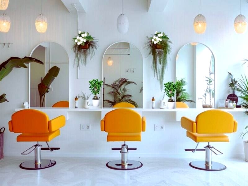 A vibrant vegan hair salon with yellow chairs, greenery, and eco-friendly decor promoting sustainable hair care.