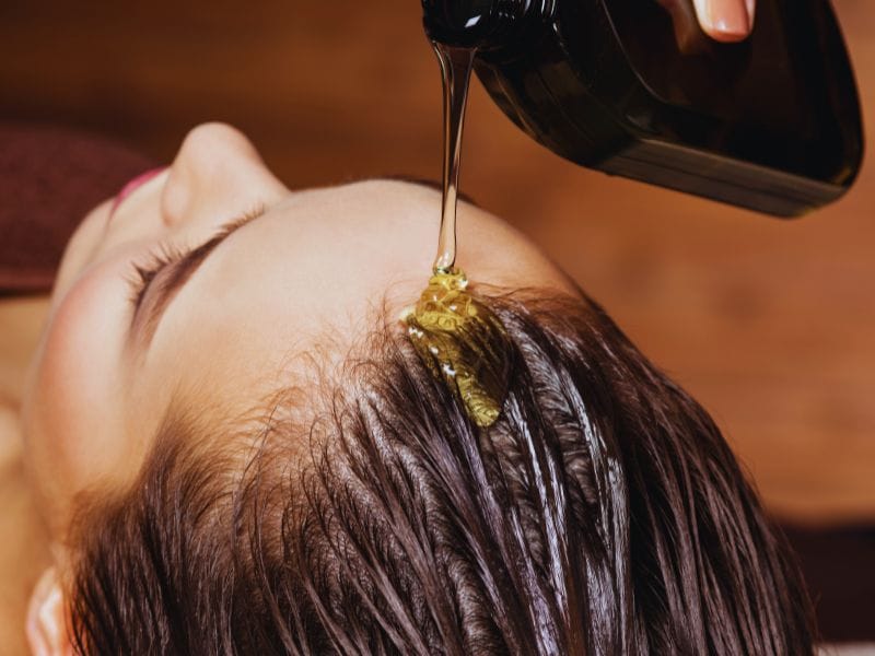 Vegan hair serum is gently applied for deep hydration, promoting healthy scalp and shiny, nourished hair.