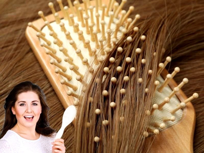 A woman holding a wooden hairbrush, highlighting the best hairbrushes for salons with a close-up view.