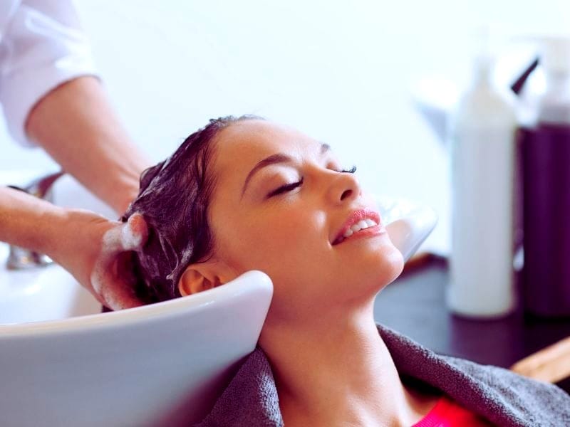 Woman enjoying deep conditioning treatment at a salon—restore hydration, strengthen hair, and improve overall hair health.