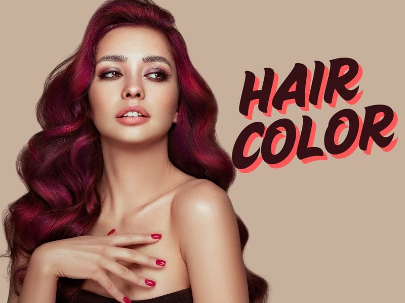 Woman with vibrant red and purple hair color, stylish waves, and bold makeup, showcasing hair color beauty.