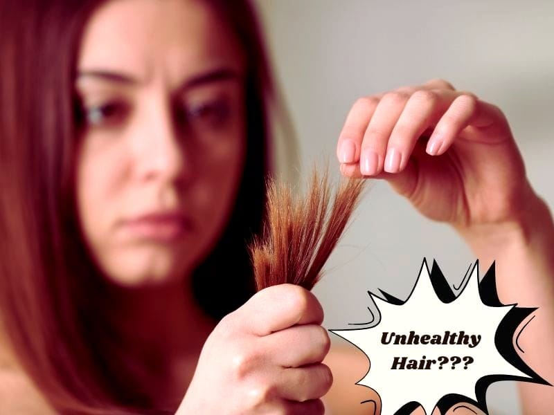 Concerned woman examining split ends, questioning unhealthy hair, highlighting the need for healthy hair care.