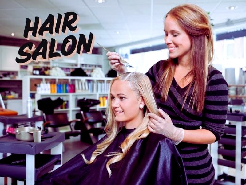 A hairstylist applying hair dye to a smiling client in a well-organized hair salon with the text "HAIR SALON."