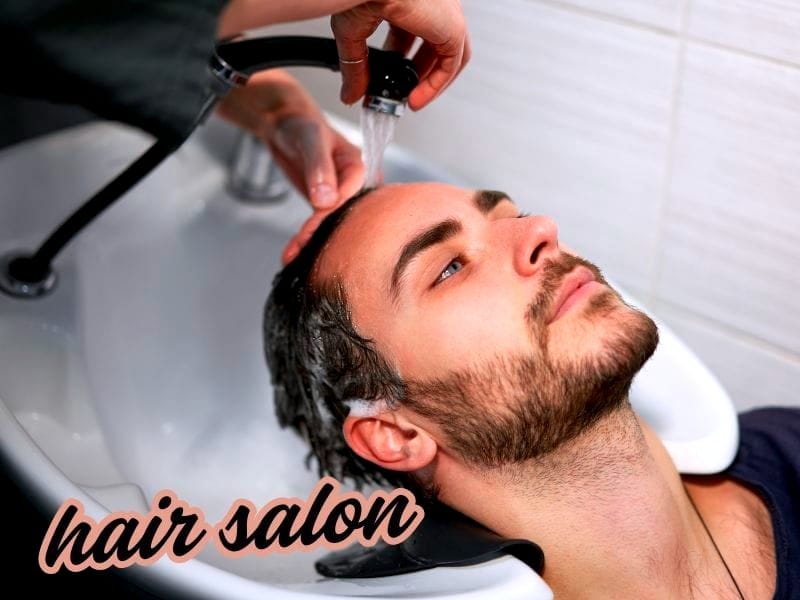 Man receiving a hair wash at a salon sink, eyes closed, relaxed; soft text overlay: "hair salon" in cursive style.