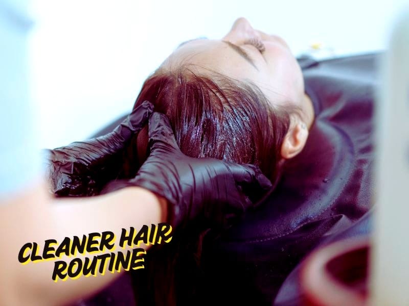 Hair stylist wearing gloves applying treatment on client's scalp with "Cleaner Hair Routine" text overlay.